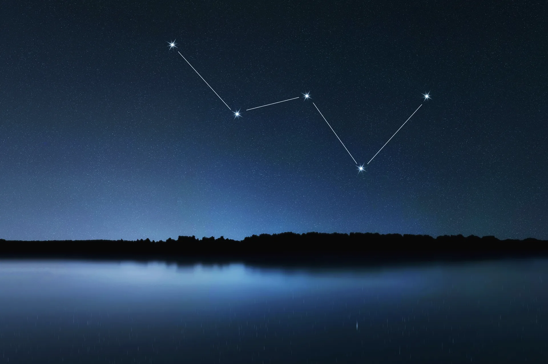 Cassiopeia constellation shown as a five-star W shape above a dark lake at night