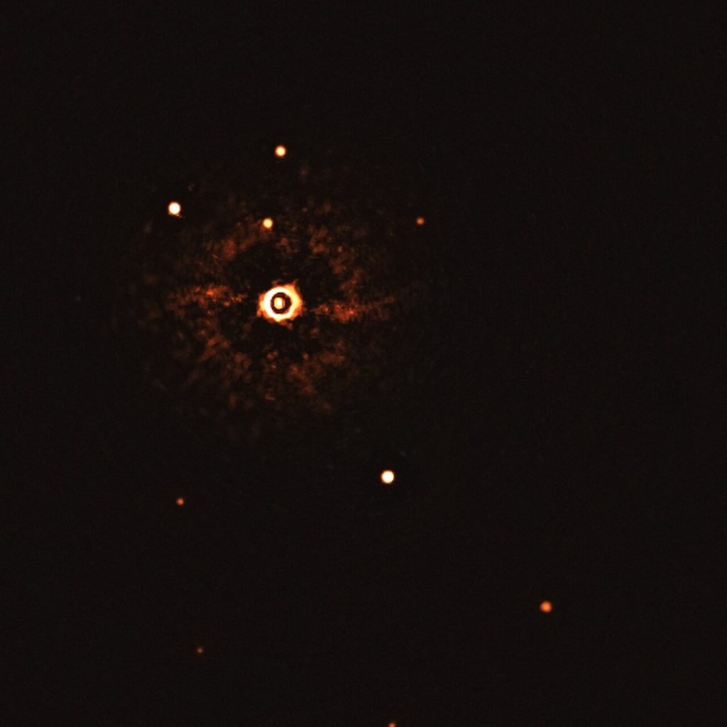 Far-infrared view of a young star surrounded by a bright ring of dust and nearby stars